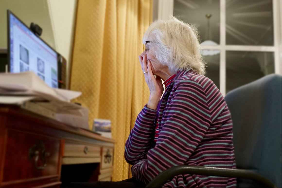 Seniorin geschockt vor einem Computer